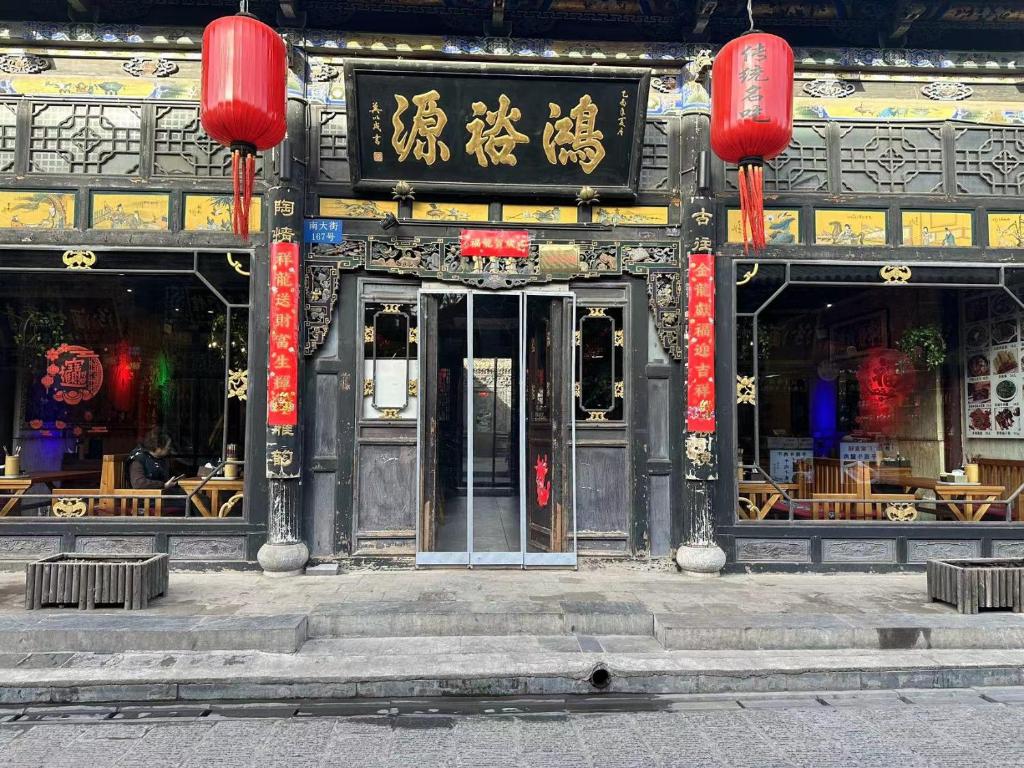 Pingyao Hongyuyuan Guesthouse في بينغياو: مدخل لمبنى عليه لافتات صينيه