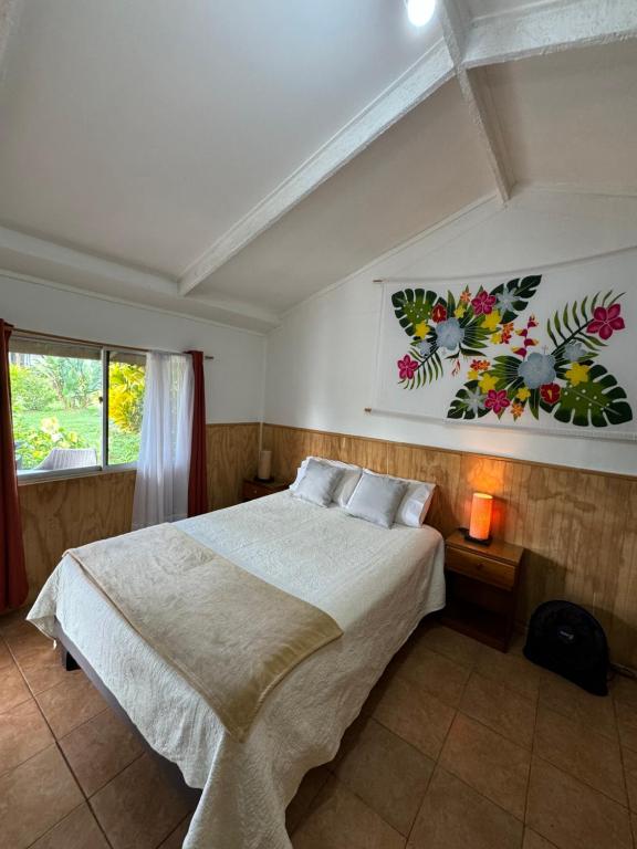 Un dormitorio con una cama grande y una ventana en Hostal Raioha, en Hanga Roa