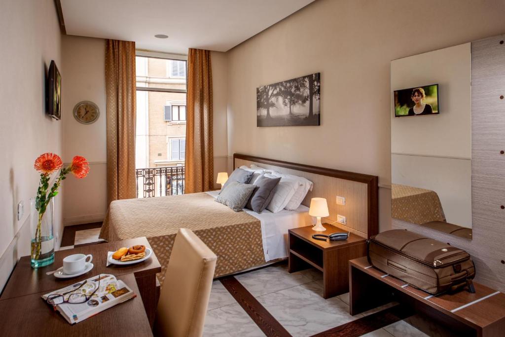 a hotel room with a bed and a dining table at Corso Grand Suite in Rome