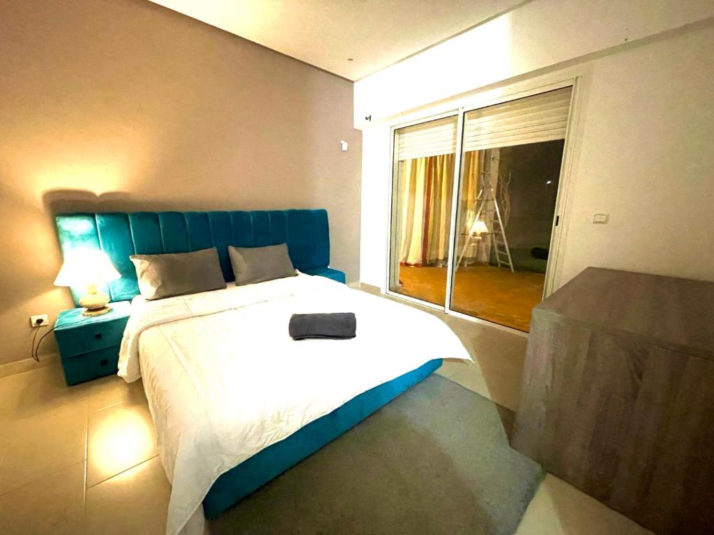 ein Schlafzimmer mit einem großen Bett und einem großen Fenster in der Unterkunft Very Nice villa with 5 rooms with private bathtooms all confort ourika Road kilomètre 9 in Marrakesch