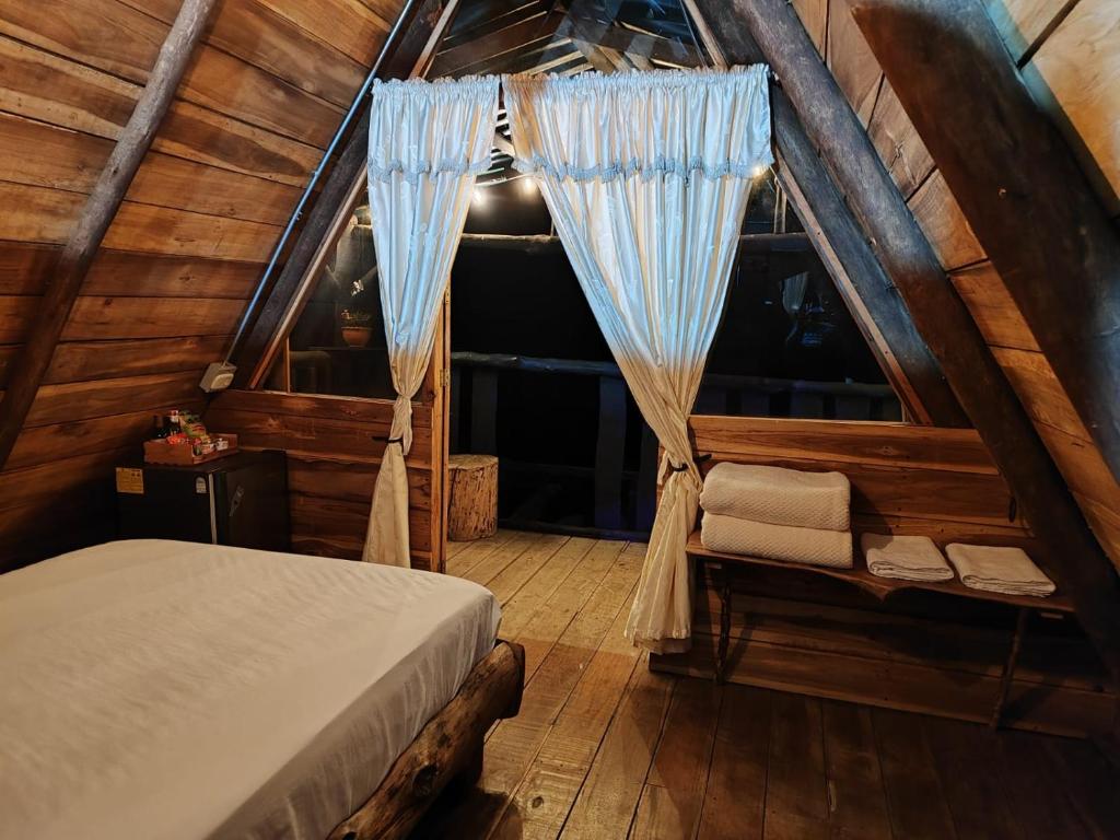 a bedroom with a bed in a wooden cabin at Alojamiento Rural Altos del Molino in Los Andes
