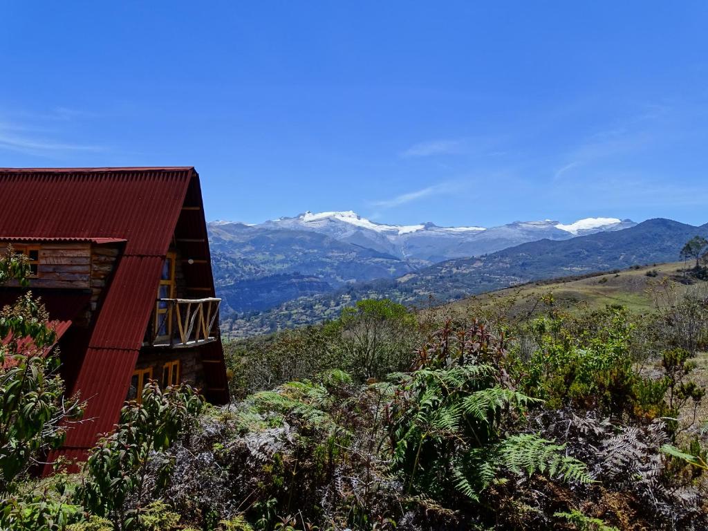 een huis op een heuvel met bergen op de achtergrond bij La Teja Experience in Güicán