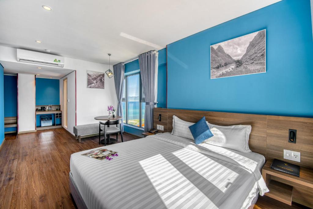Un dormitorio con una cama grande con paredes azules. en NATA-Căn hộ du lịch Nha Trang, en Nha Trang