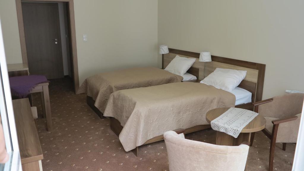 ソポトにあるRoFel Pokoje Gościnneのベッド2台とテーブルが備わるホテルルームです。