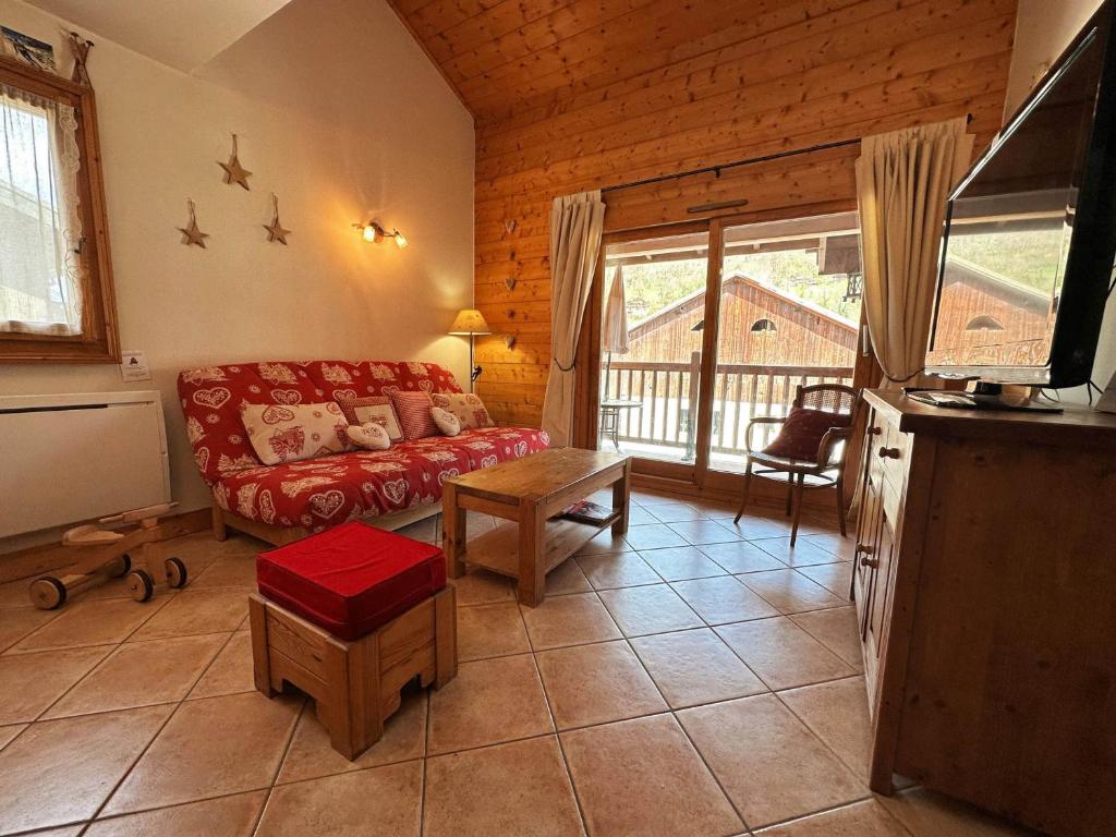 een woonkamer met een rode bank en een tv bij Appartement Samoëns, 3 pièces, 6 personnes - FR-1-624-158 in Samoëns