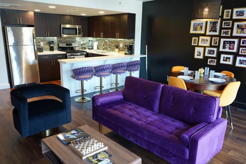 a living room with a purple couch and a kitchen at Downtown LA - Mamba Suite - Free Indoor Parking! in Los Angeles