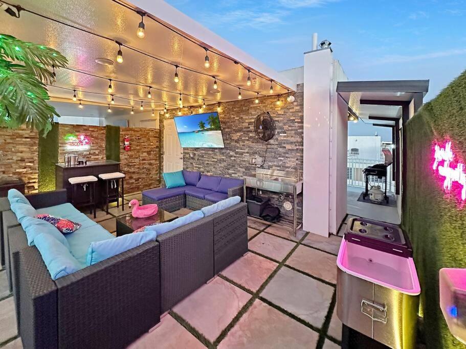a patio with a couch and a table and a grill at Vacay Spot experience Luna Sky! 65" TV BAR, BBQ, SHOWER massage jets, music, go to FL Keys in Homestead