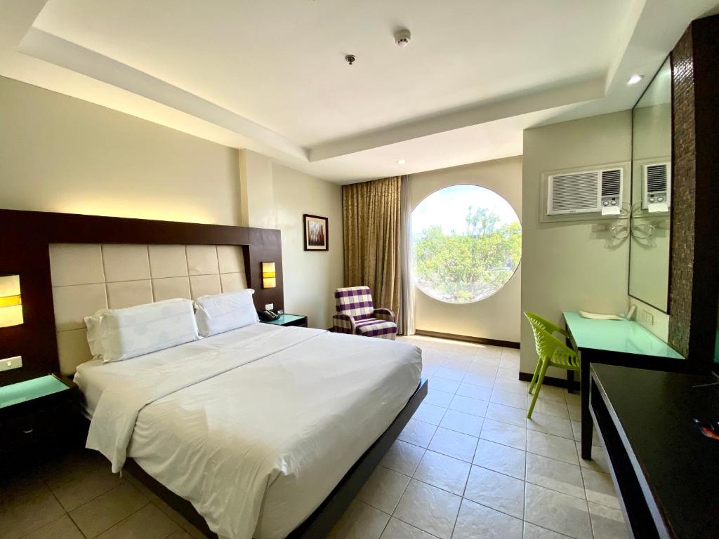 Postel nebo postele na pokoji v ubytování Circle Inn Hotel and Suites Bacolod