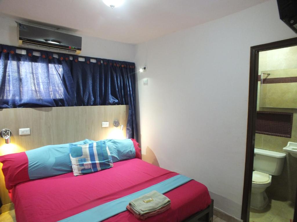 een slaapkamer met een bed met roze en blauw bij Hotel malecón del Rio in Barranquilla