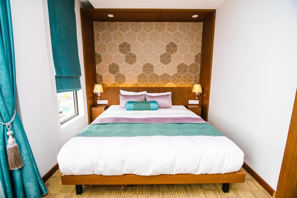 a bedroom with a large bed with a wooden headboard at HANA Stay in Hanoi
