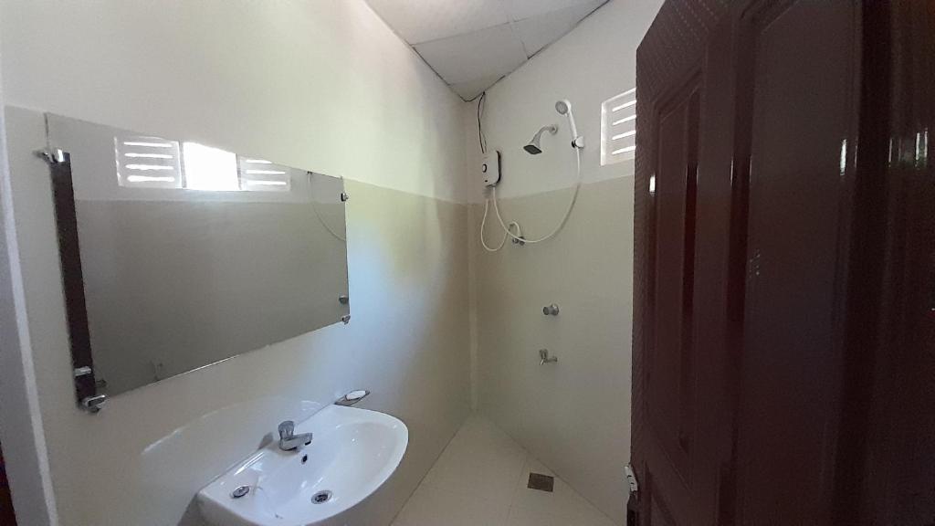 a white bathroom with a sink and a mirror at Vidatha Villa in Bandarawela