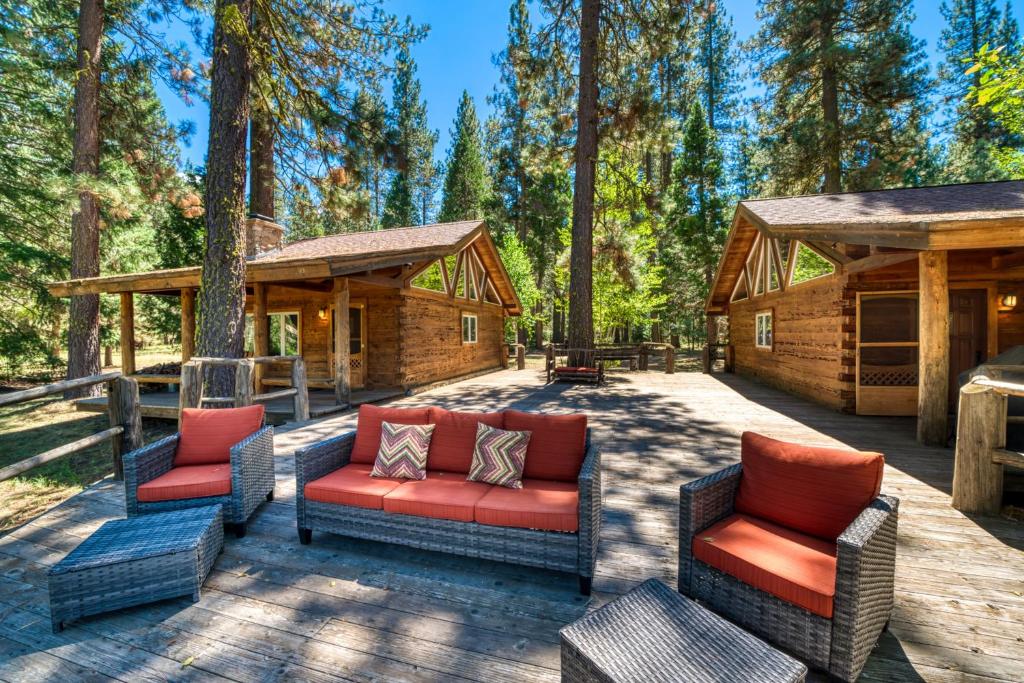 un patio con sofás y sillas frente a una cabaña en River Cabins | The Lost Sierra Ranch en Graeagle