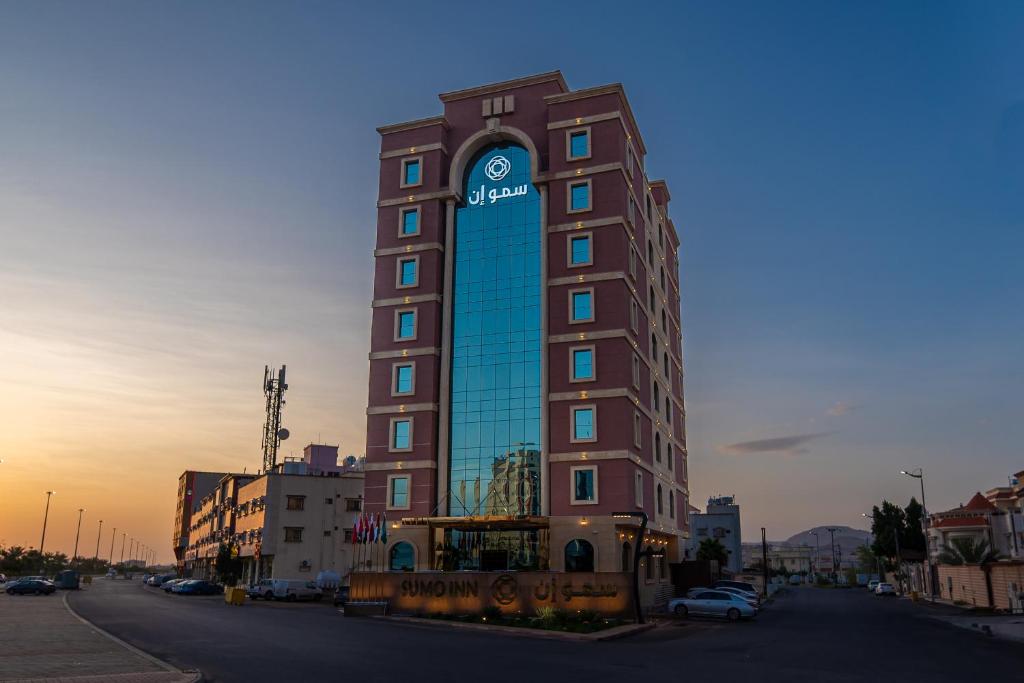 un edificio alto con un reloj encima en فندق سمو ان - Sumo inn Hotel en Najrán