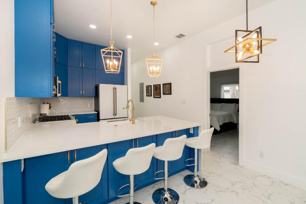 a kitchen with blue cabinets and white counters and stools at Perfect Spacious Modern Home w/Hot Tub in San Antonio