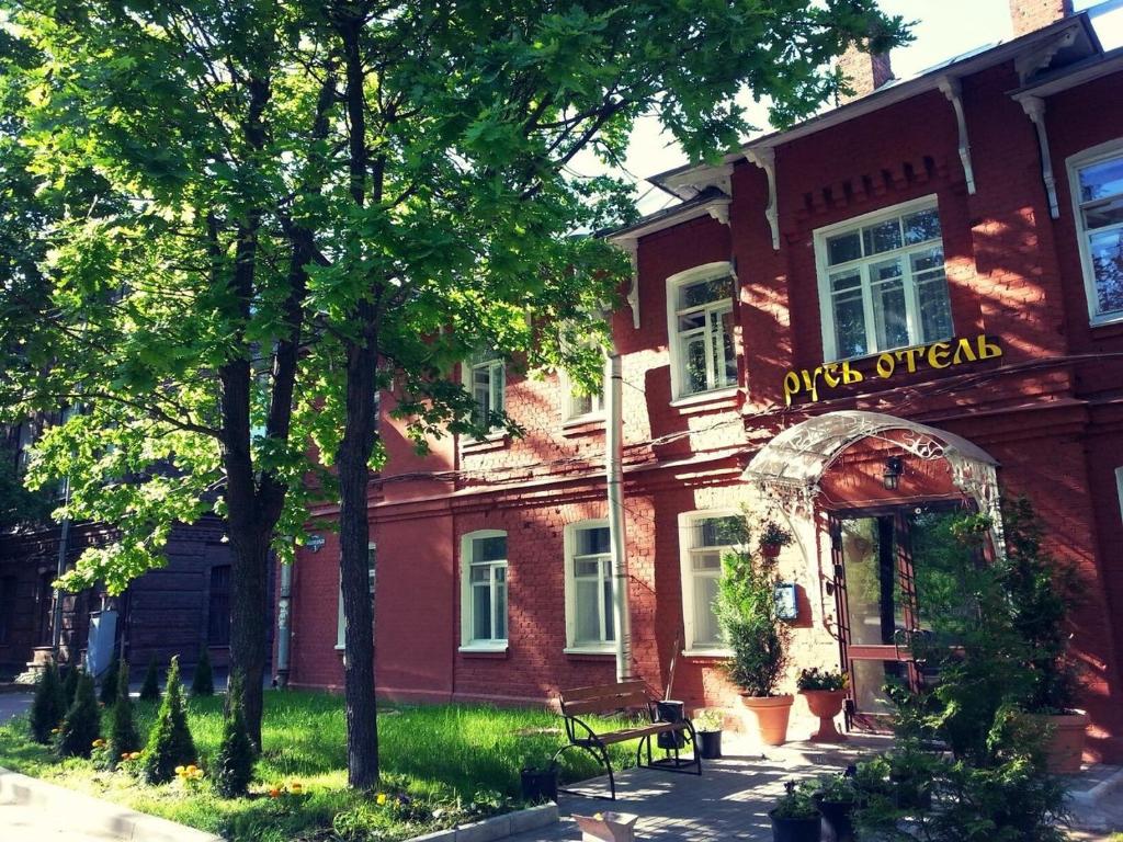 a red brick building with an archway in front of it at Русь Отель in Kolpino