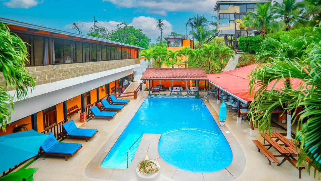 an overhead view of a resort swimming pool with blue chairs at Hotel La Hacienda in Quesada