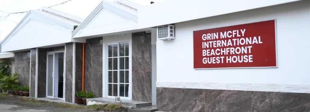 a building with a sign on the side of it at GRIN MCFLY INTERNATIONAL BEACHFRONT GUEST HOUSE in Fuerte