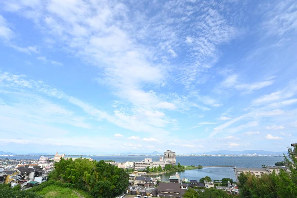 Blick auf eine Stadt mit wolkigem Himmel in der Unterkunft Biwako Hanakaido in Ōtsu