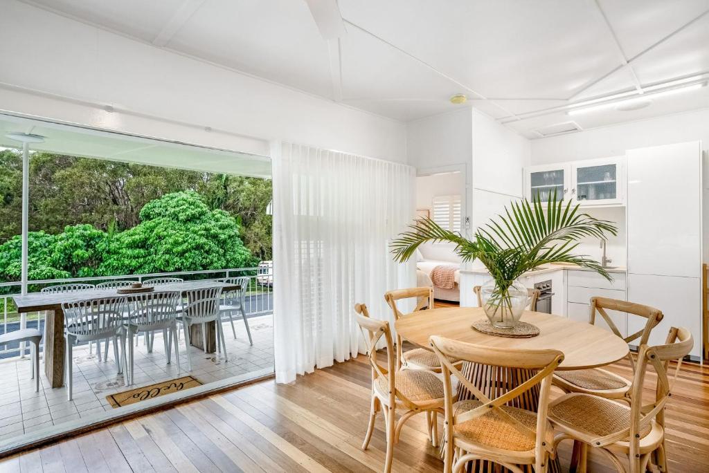 a dining room with a table and chairs and a balcony at 1-29 Beech Street in Evans Head