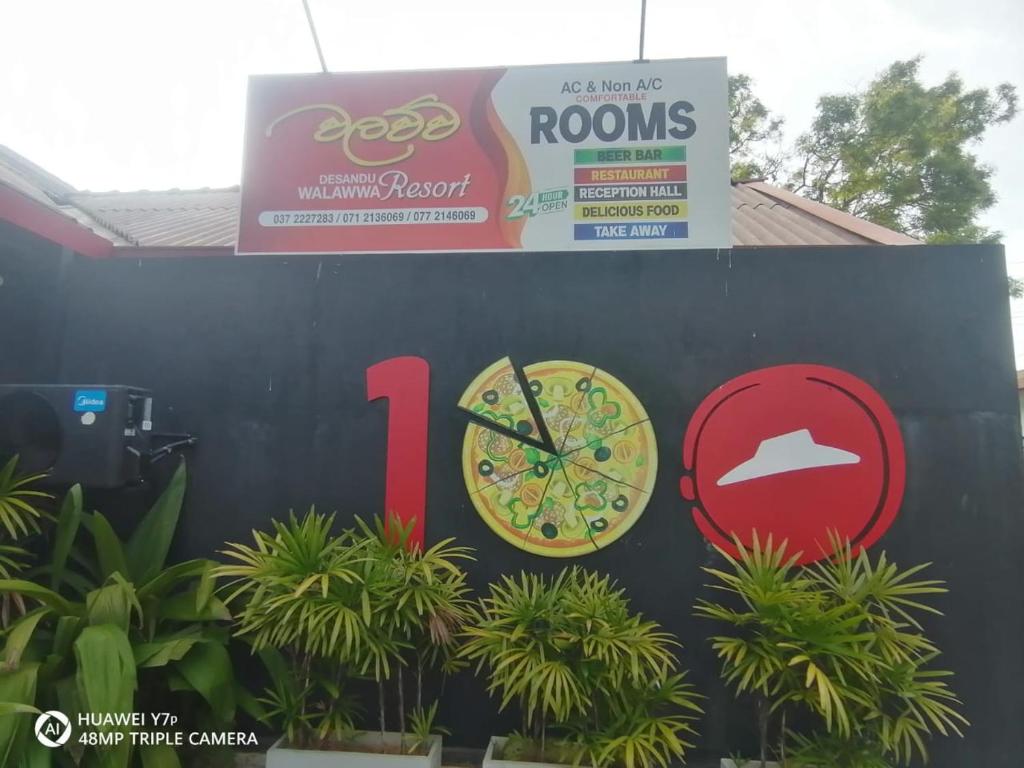 um sinal para uma pizzaria com um relógio em Walawwa Resort em Kurunegala