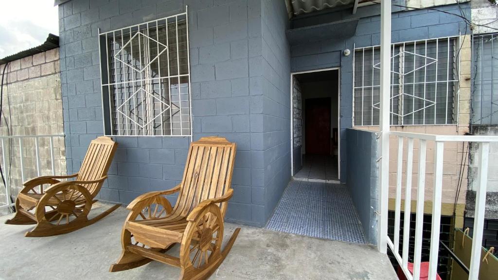 dos sillas sentadas frente a un edificio azul en Apartamento dos habitaciones, en Mexicanos