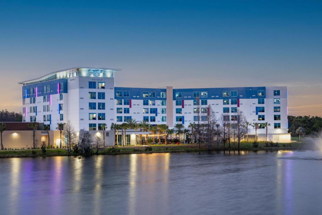 a large building next to a large body of water at Aloft Orlando Lake Nona in Orlando