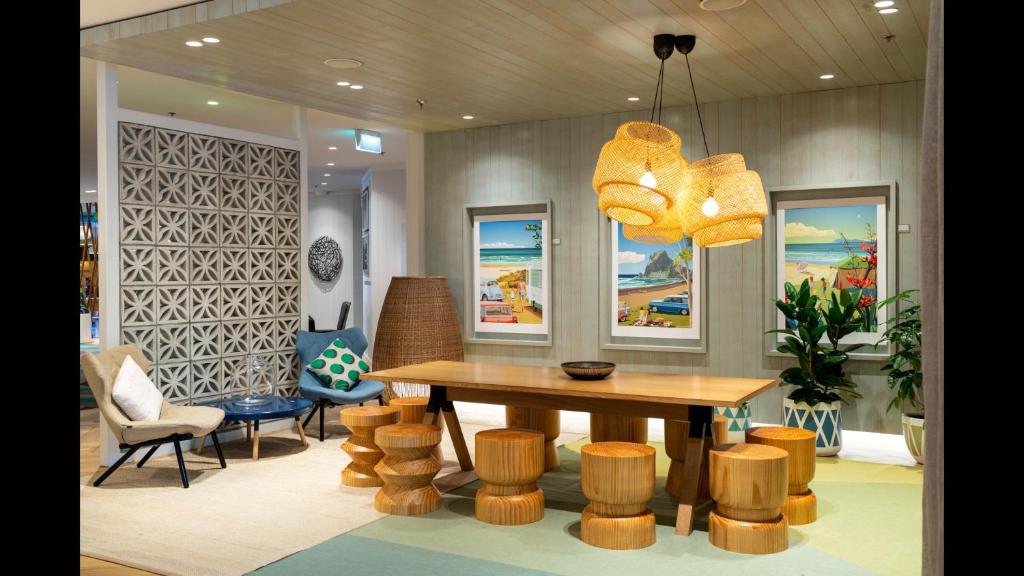 a dining room with a table and chairs and a chandelier at Holiday Inn Auckland Airport, an IHG Hotel in Auckland