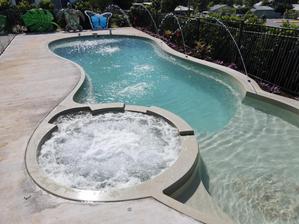 una piscina con vasca idromassaggio in un cortile posteriore di Forever Endeavour a Mission Beach