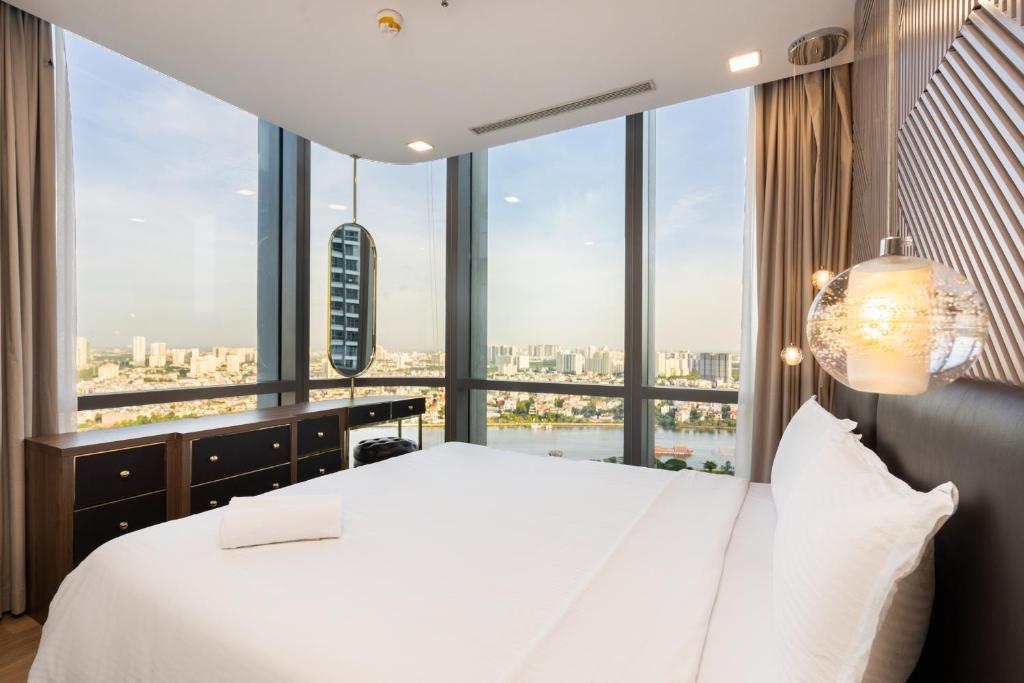 1 dormitorio con cama blanca y ventana grande en Landmark 81 President Suite - Vinhome Central Park, en Ho Chi Minh