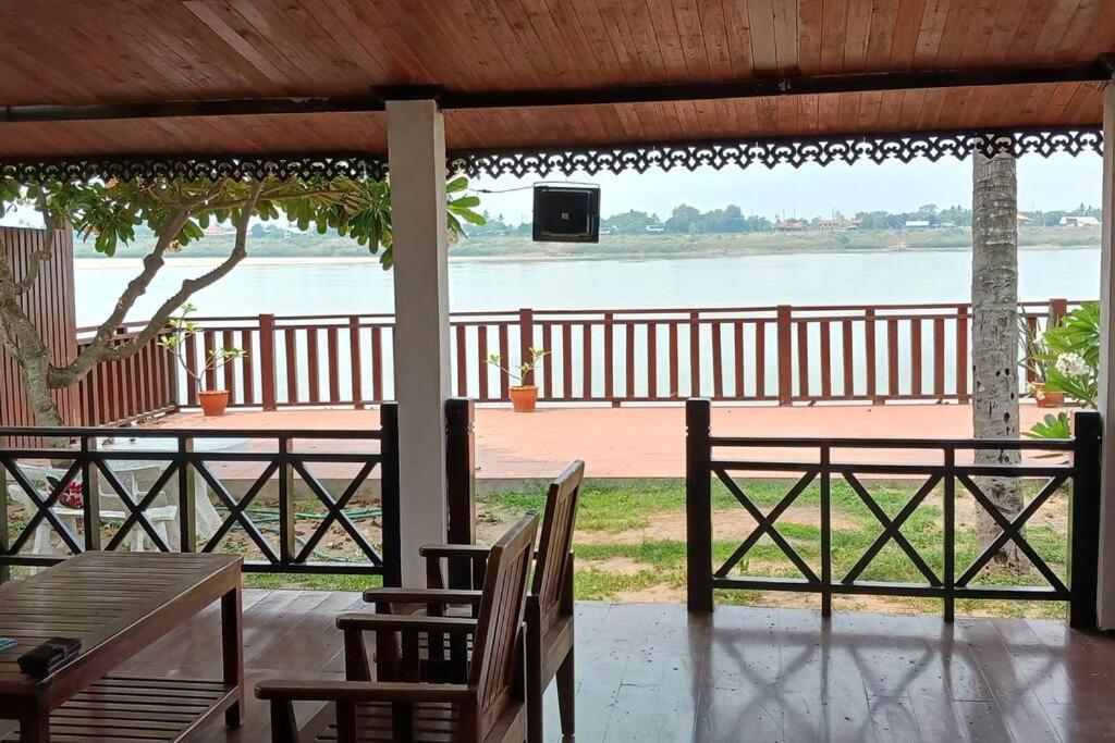 d'une terrasse avec tables et chaises et vue sur l'eau. dans l'établissement MEKONG VIEW VILLE, à Vientiane