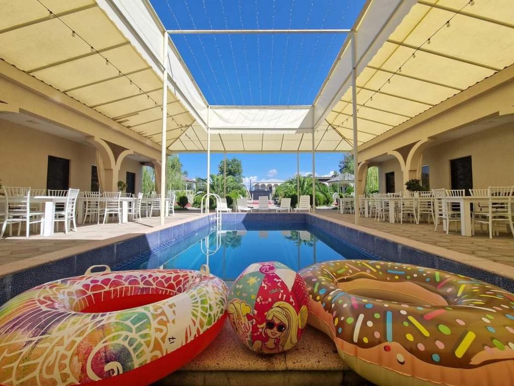 TsqaltuboにあるHotel Oasis Villaの建物内のスイミングプール(大型インフレータブルチェア2脚付)