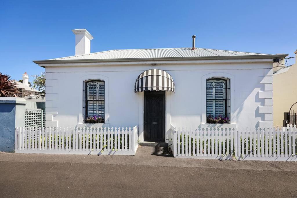 a white house with a white picket fence at Thyme Cottage Warrnambool in Warrnambool