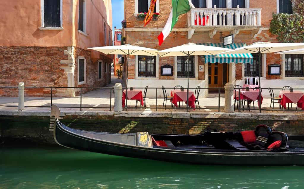 a gondola in the water in front of a restaurant at Hotel Messner in Venice