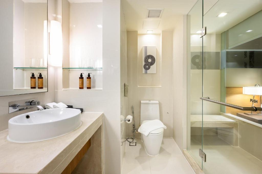 a white bathroom with a sink and a shower at Centara Grand at Central Plaza Ladprao Bangkok in Bangkok