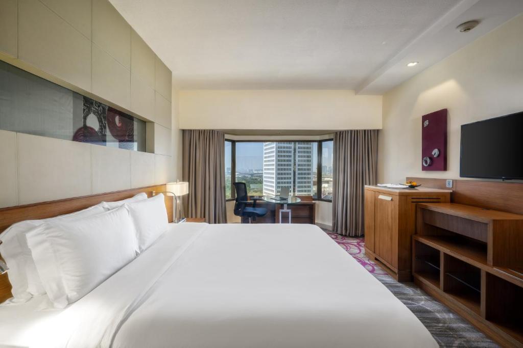 um quarto de hotel com uma cama e uma televisão em Centara Grand at Central Plaza Ladprao Bangkok em Bangkok