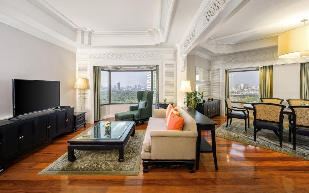 A large living room with a television, sofa, dining table and city view.