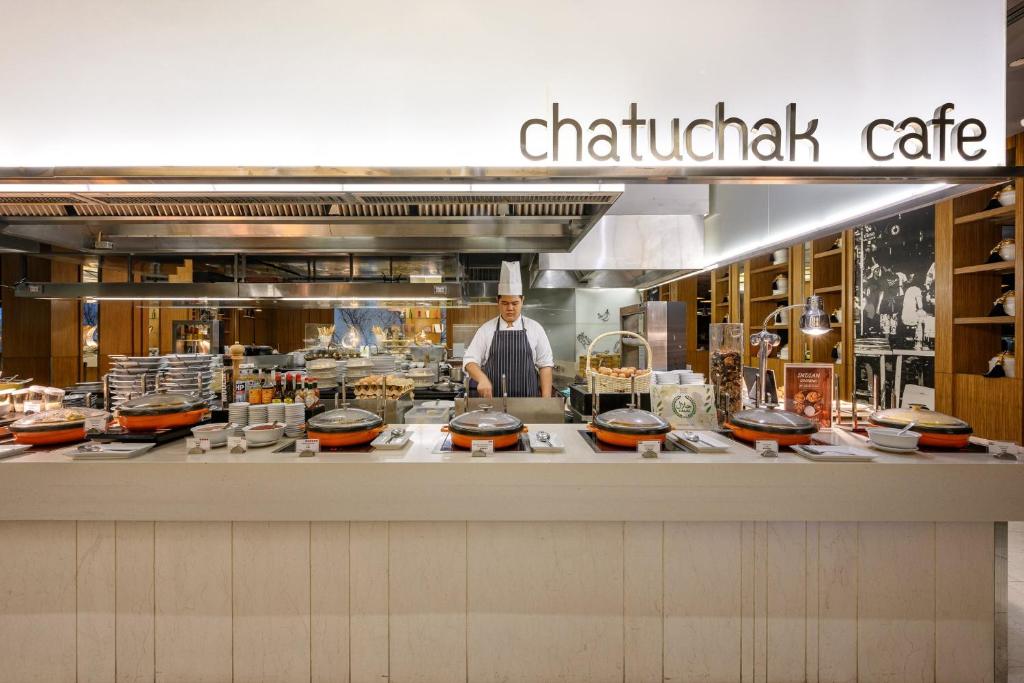 A chef works at the Chatuchak Cafe live-cooking counter.