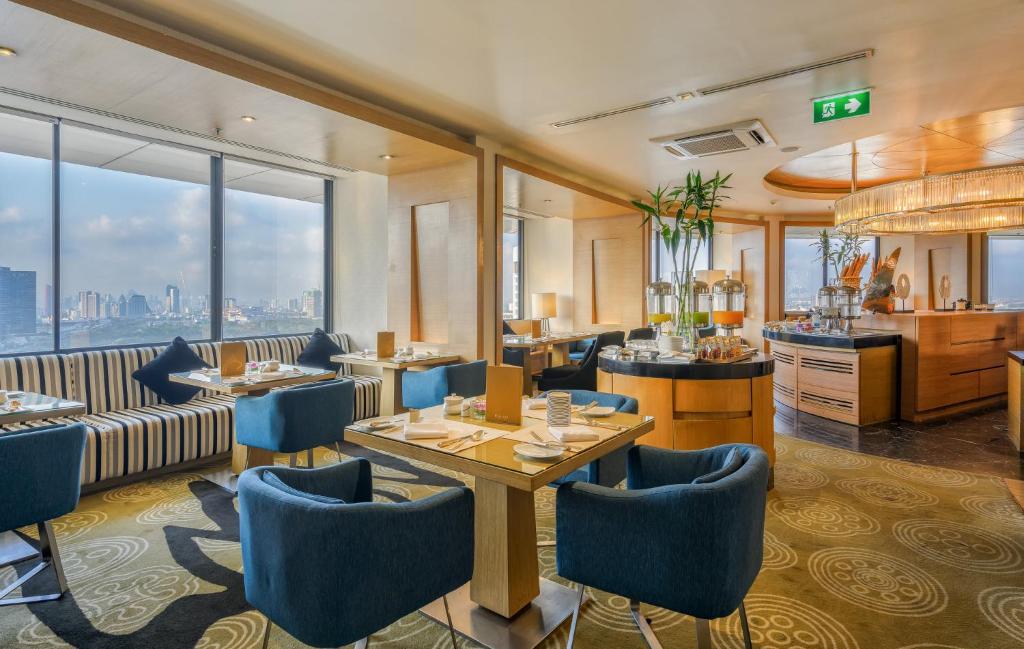 A bright club-style dining lounge with city views and a buffet counter.