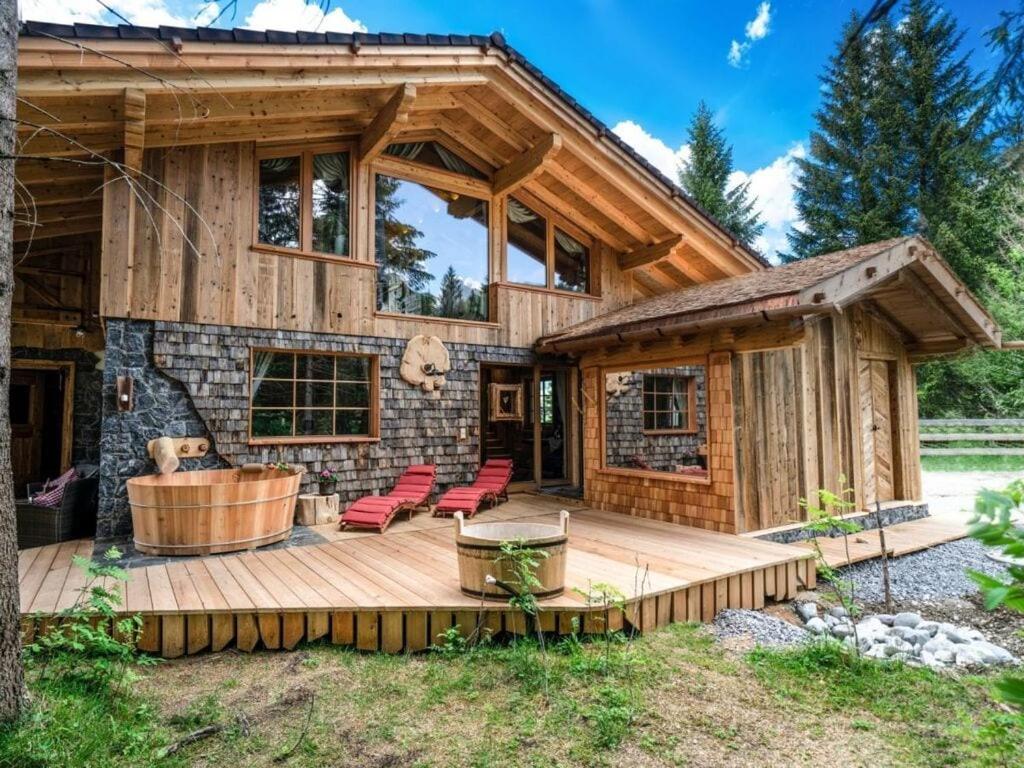 una baita di tronchi con terrazza e vasca idromassaggio di Lush holiday home with sauna a Grän
