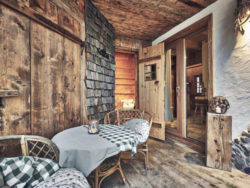 Habitación con mesa, sillas y pared de madera. en Rustic holiday home with sauna en Grän