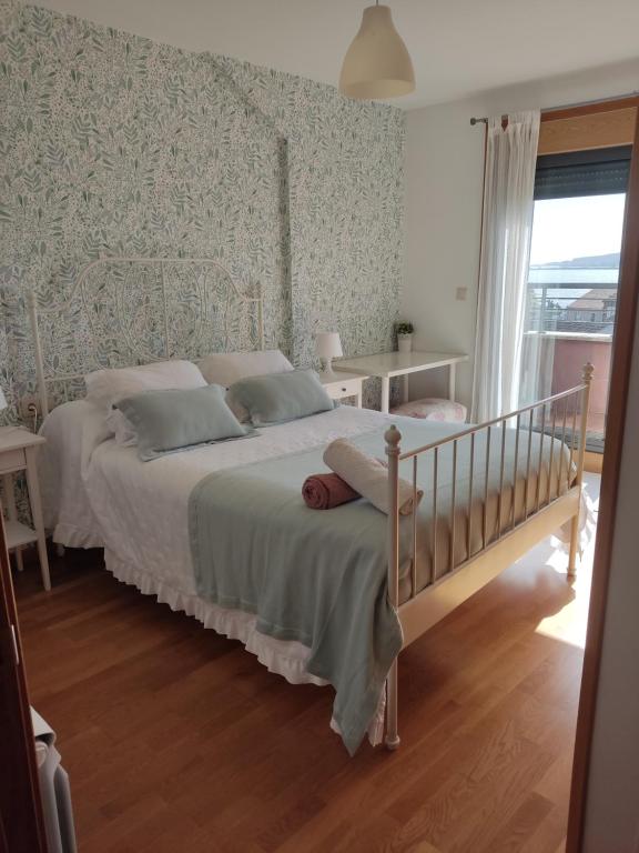 a bedroom with a white bed and a window at Cambados Apartamento VUT-PO-TU986D in Cambados