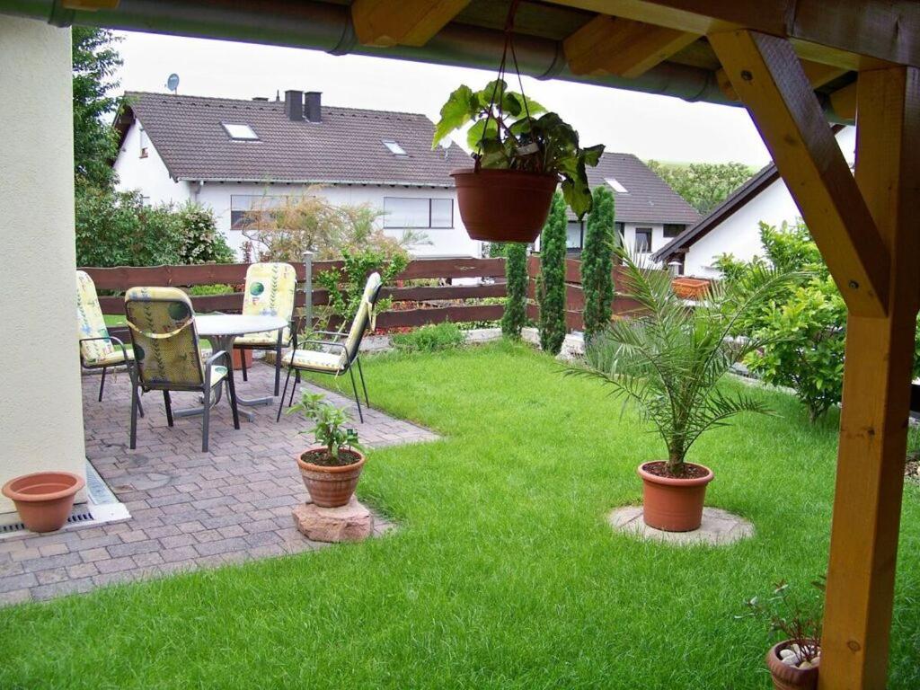eine Terrasse mit einem Tisch, Stühlen und Pflanzen in der Unterkunft Holiday apartment oasis 
