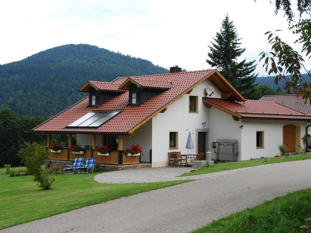 une maison blanche avec un toit rouge dans l'établissement Schellenberg Modern retreat, à Deggendorf