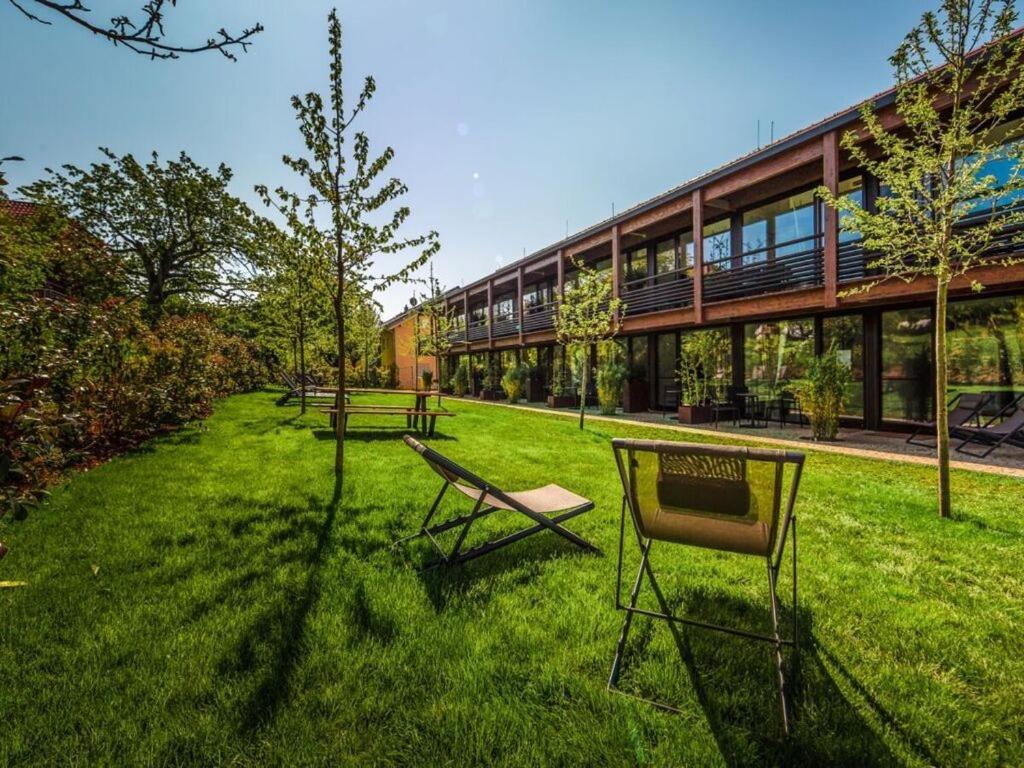 eine Gruppe von Bänken, die im Gras vor einem Gebäude sitzen in der Unterkunft Suite apartment 80 sqm in Gundholzen