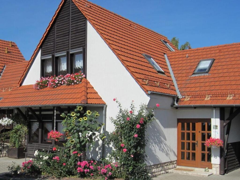 een wit huis met rode daken en bloemen bij Rose ambience Modern retreat in Bad Langensalza