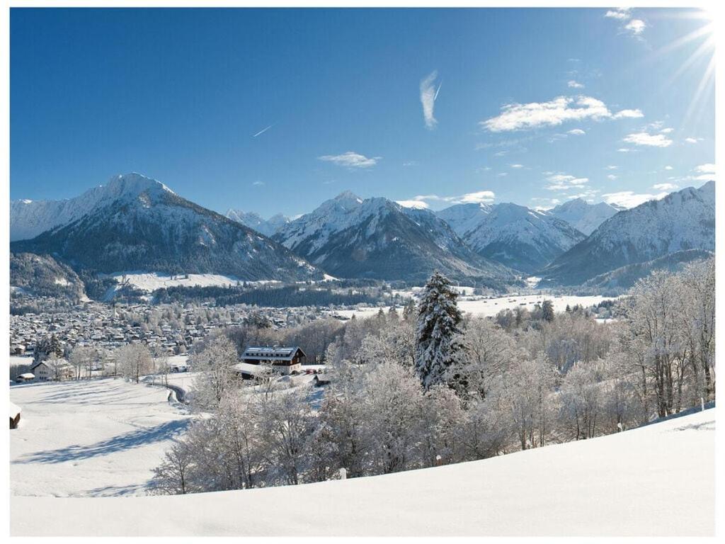 a snow covered mountain with a town in the distance at Oberstdorf dream view - Alpine star in Oberstdorf