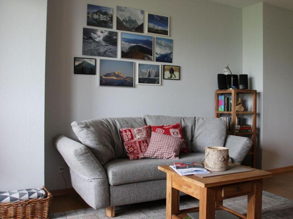sala de estar con sofá gris y cuadros en la pared en Hochgrat view in Steibis, Haus Akelei en Steibis