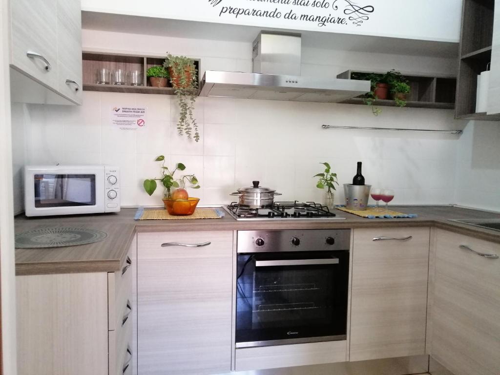 a kitchen with a stove and a microwave at HoliHome_La Sirena 50m dal Mare in Tortoreto Lido