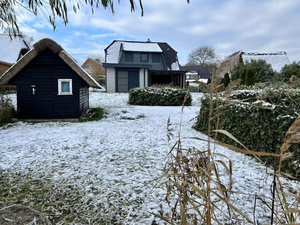 una casa con techo de paja en la nieve en Attractive holiday home by the lake, en Großzecher