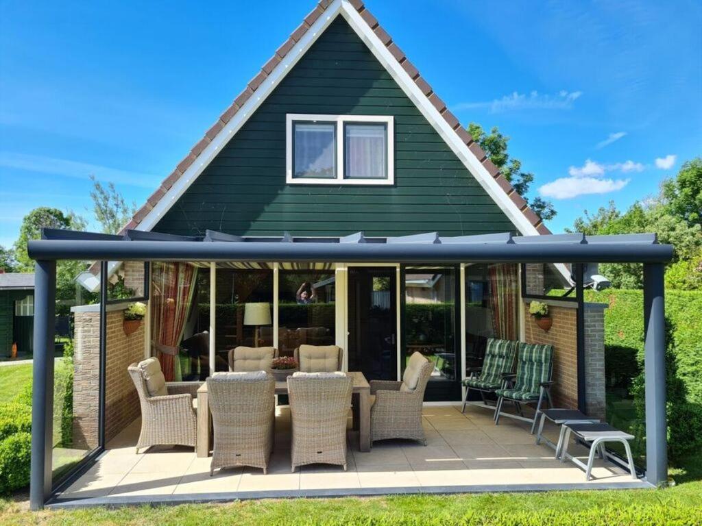 a house with a conservatory with a table and chairs at Sunshine Comfortable holiday residence in Sint Maarten